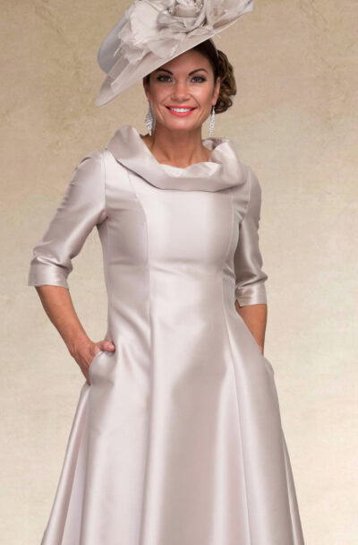 Woman in an elegant silver satin dress and matching hat.