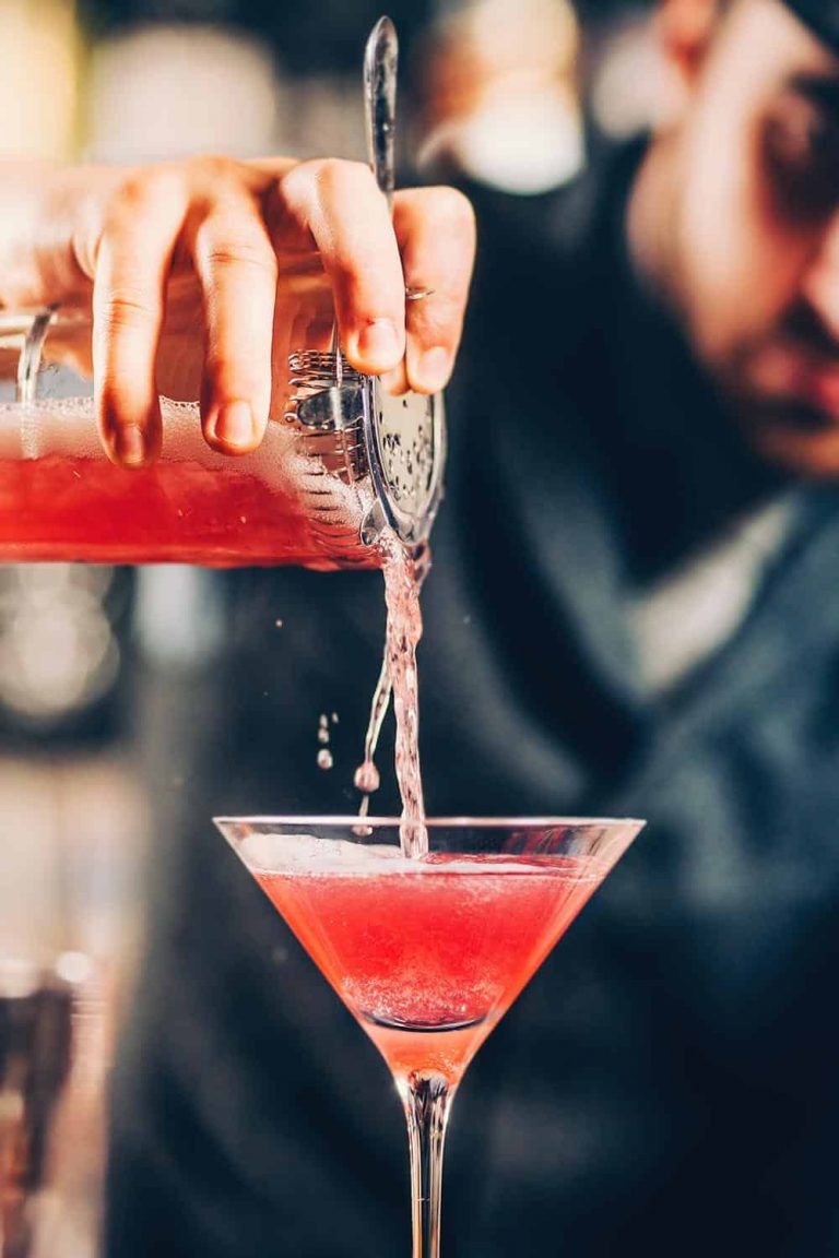 Mixologist pouring a pink cocktail into a martini glass at Catherines of Partick.