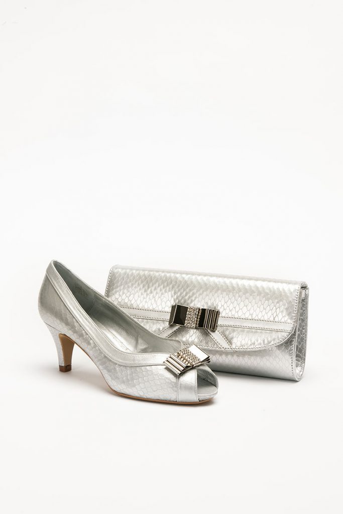 Low heeled silver shoe with bow detail to front with matching bag
