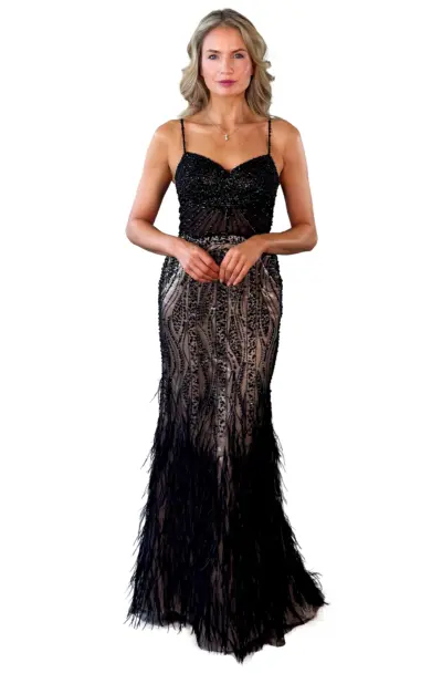 A woman models a black beaded and feathered evening gown.