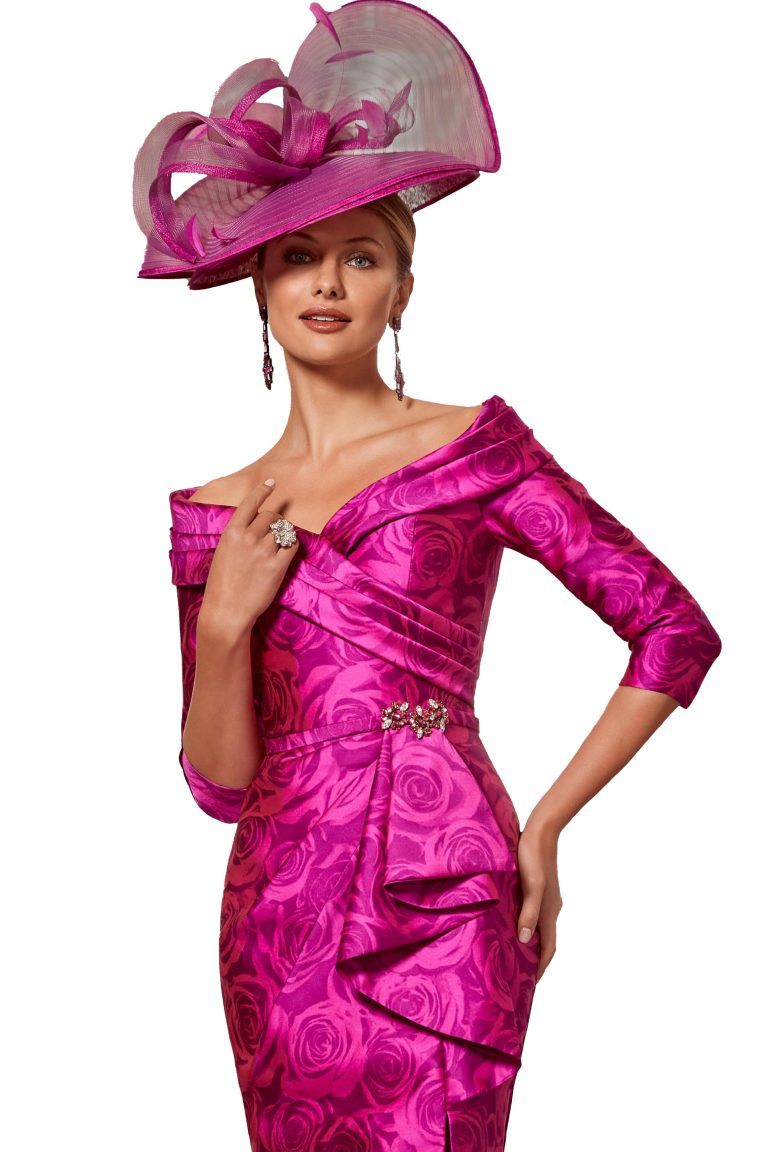 Elegant woman in vibrant pink dress and large matching hat for special occasion.