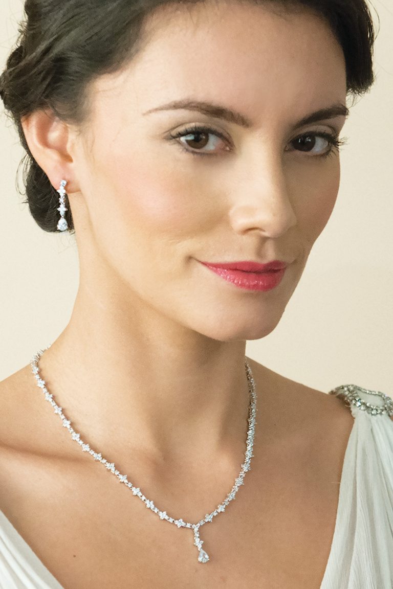 Woman wearing diamond necklace and earrings for elegant look.