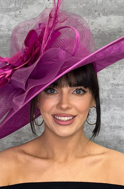 Elegant pink hat with crinoline wave and floral details for special occasions.