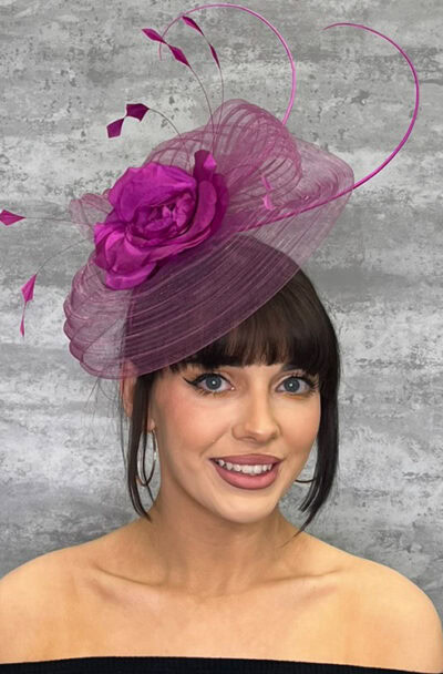 Elegant pink hat with flower and netting, perfect for events and weddings.