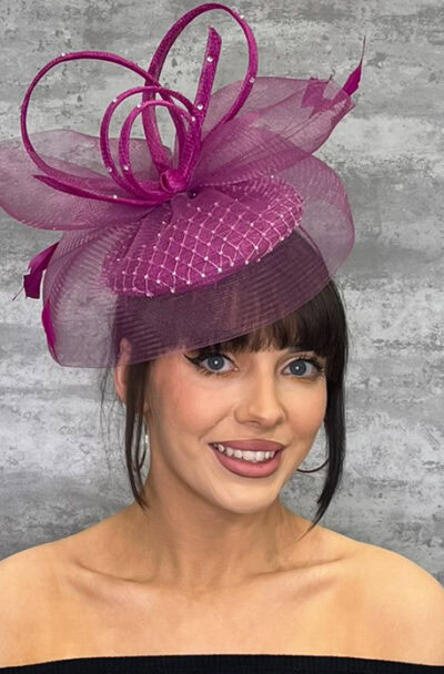 Elegant pink hat with sinimay loops and veiling for special occasions.