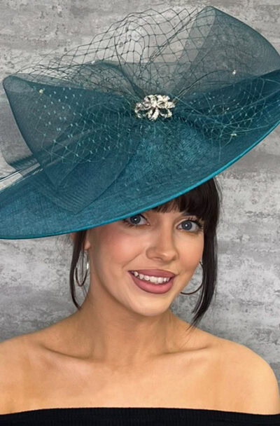 Elegant teal hatinator with large quills and netting for special occasions.