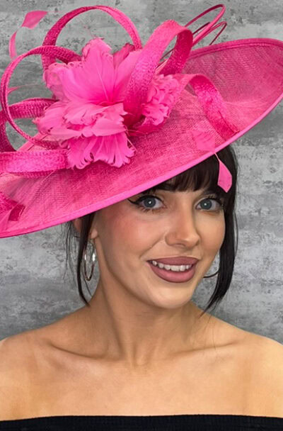 Pink hat with feathers and sinimay loops, stylish headwear for special occasions.