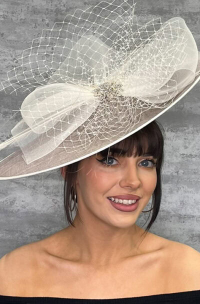 Elegant white saucer hat with veiling detail for special occasions.
