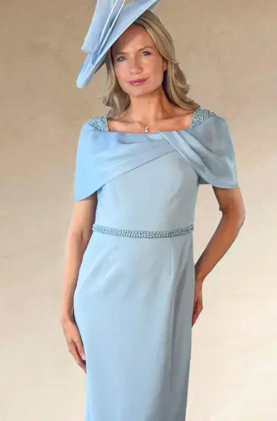 Woman in an elegant light blue dress and matching hat.