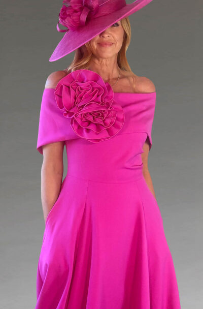 A woman in a vibrant pink dress and matching hat.