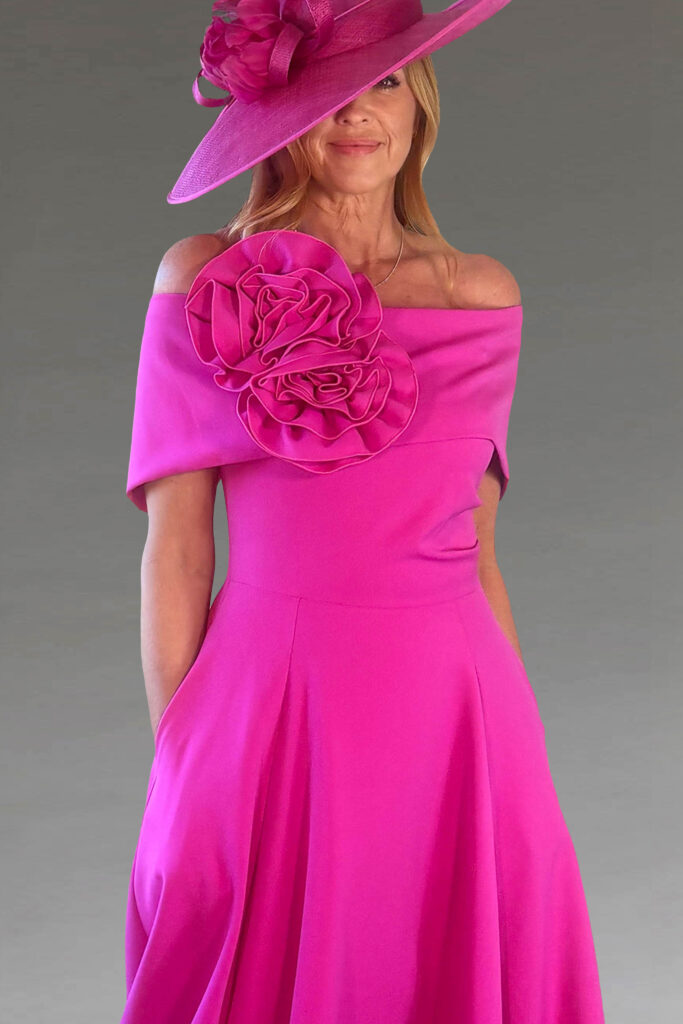 A woman in a vibrant pink dress and matching hat.
