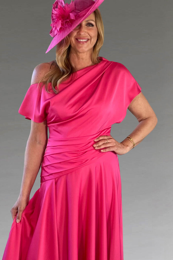 A woman in a vibrant pink dress and matching hat.