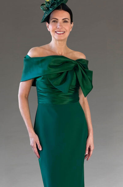 Woman in an elegant emerald green off-the-shoulder dress.