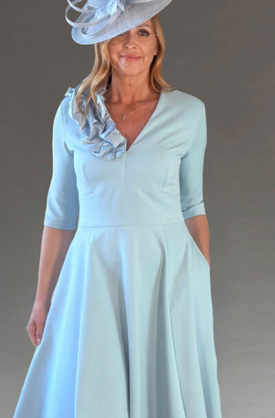 A woman wearing a light blue dress and fascinator hat.