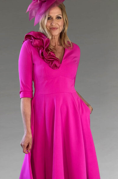 A woman in a vibrant fuchsia dress and fascinator.