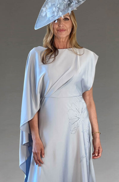 Woman in an elegant pale blue dress and fascinator.