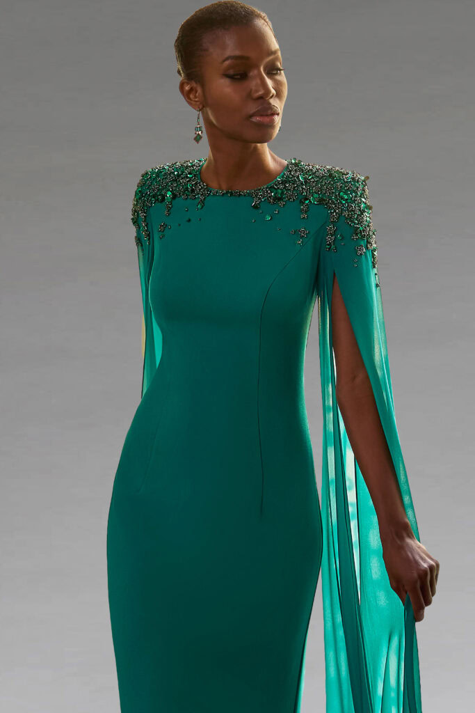 Elegant fitted full-length dress with caped sleeves and embellished shoulders.