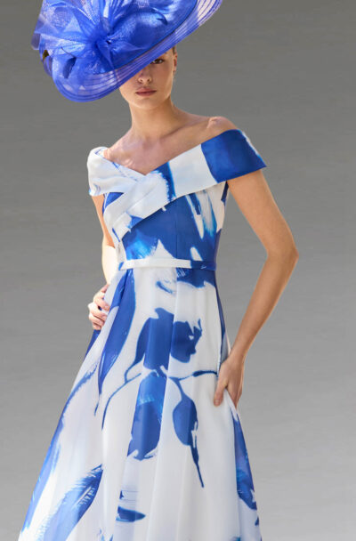Woman in blue and white floral dress and fascinator.