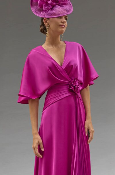 Elegant woman wearing a vibrant fuchsia dress and matching hat.