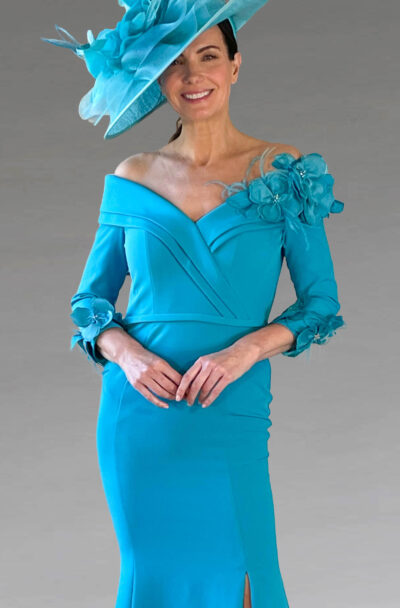 A smiling woman in a turquoise off-the-shoulder dress and hat.