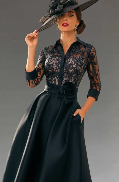 A woman models an elegant black lace dress and hat.