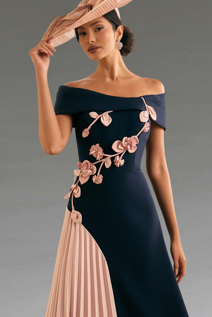 Elegant woman in a navy dress with pink floral details.