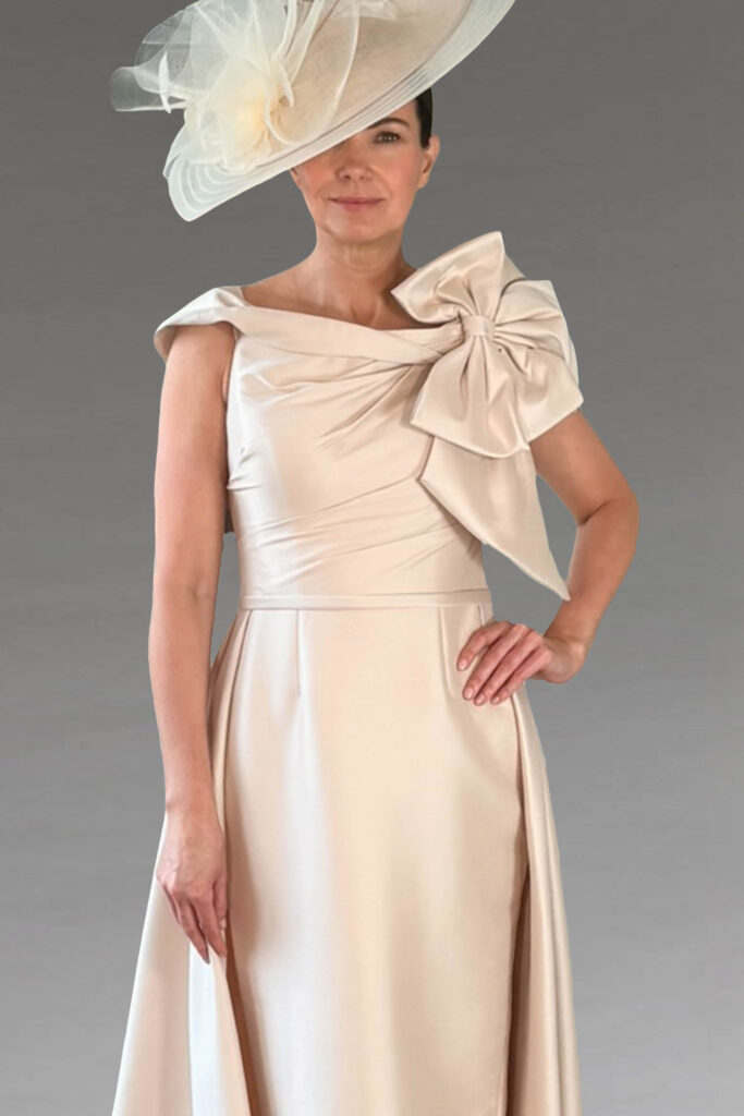 Woman in an elegant cream dress with a matching hat.