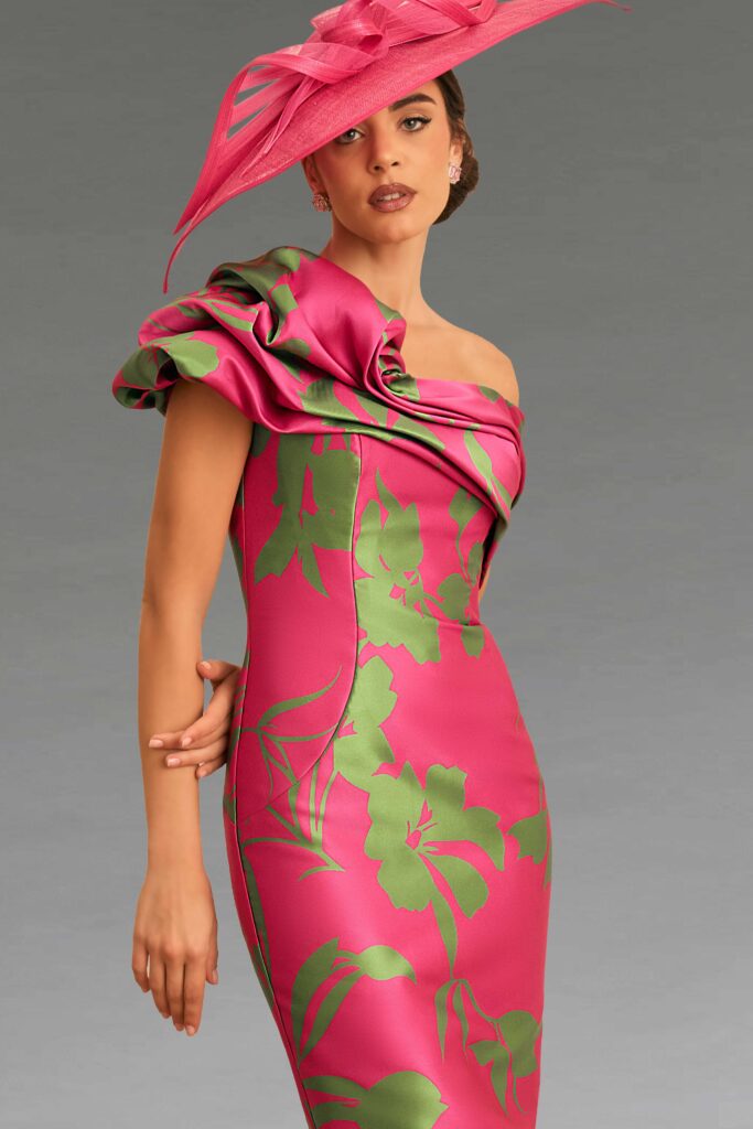 A woman in a pink floral dress and matching fascinator.