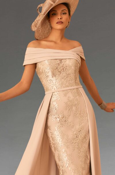 A woman in an elegant beige dress and hat.