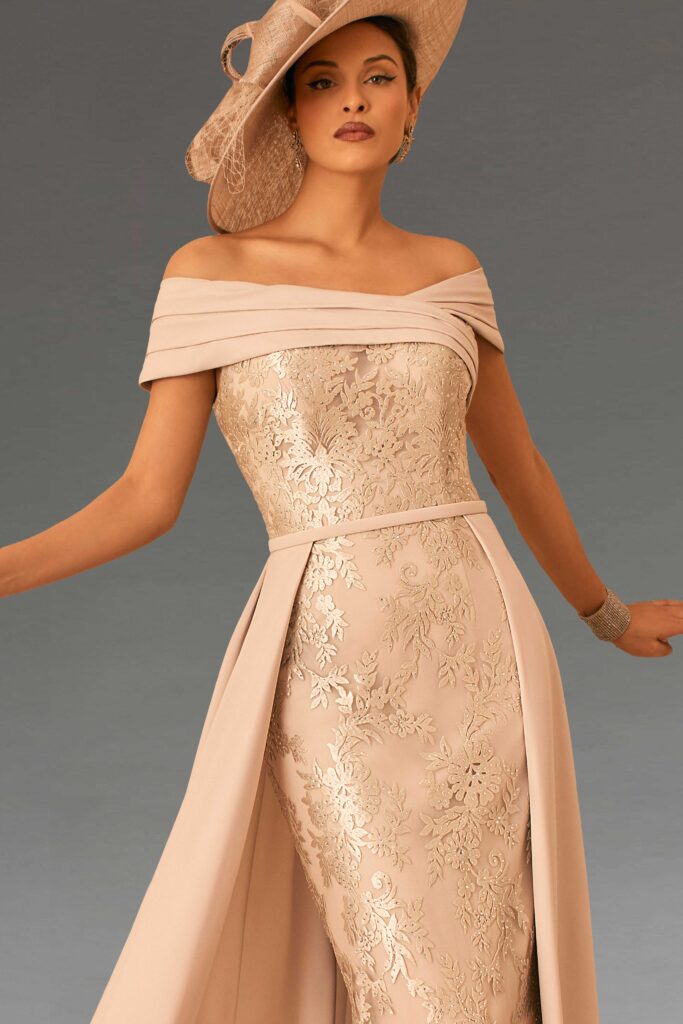 A woman in an elegant beige dress and hat.