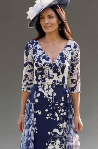 Woman in a blue and white floral dress and hat.