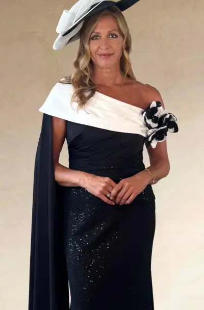 A smartly dressed woman in a monochrome gown and hat.
