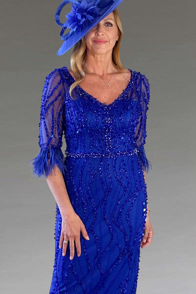 A woman in a royal blue sequined dress and hat.