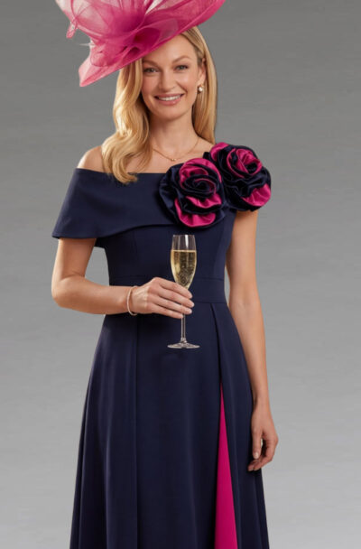 A woman in a navy dress and pink fascinator.