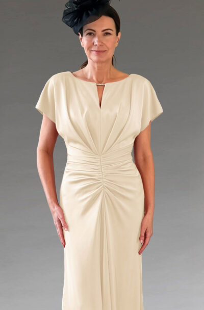 A woman in an elegant cream dress and black fascinator.