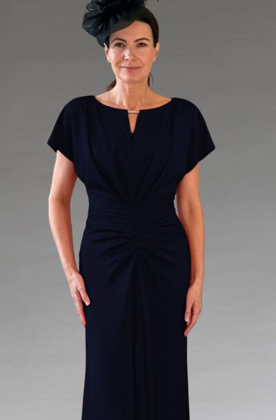Woman in an elegant navy ruched dress and fascinator.
