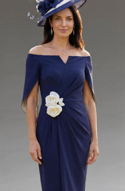 A woman in an elegant navy dress and matching hat.
