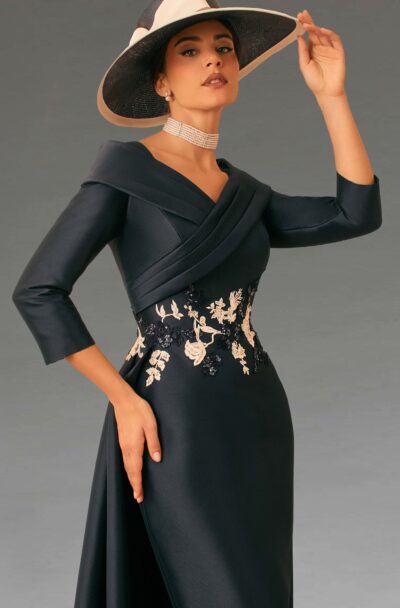 An elegant woman in a navy dress and hat.
