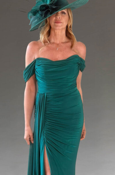 Woman in an elegant green off-the-shoulder dress and hat.