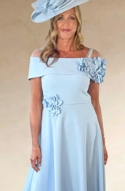 A woman in an elegant light blue dress and hat.