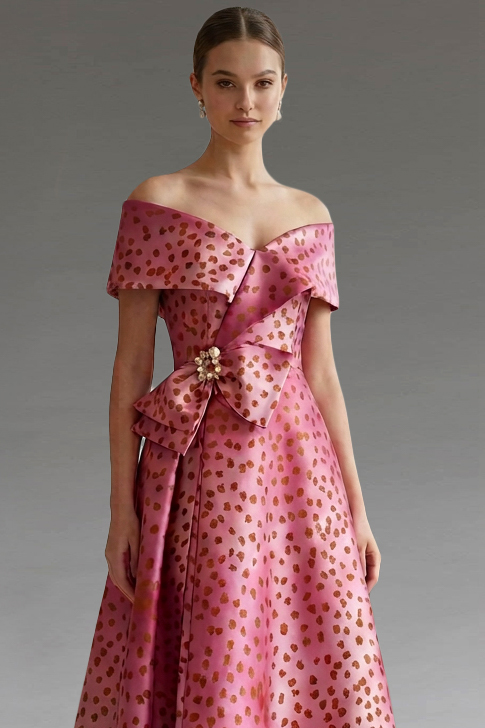 Model in a pink off-the-shoulder gown with gold spots.
