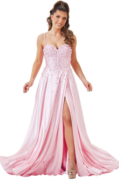 A woman models a pink satin gown with embellishments.