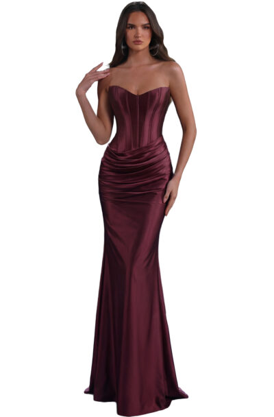 A woman models a burgundy strapless corset gown.