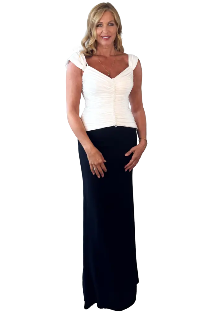 A woman in an elegant white top and long skirt.